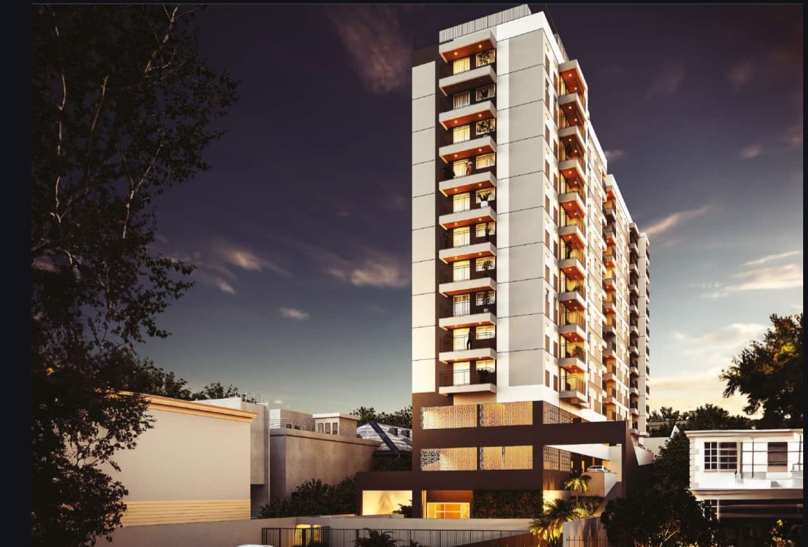 Fachada noturna de edifício residencial moderno com varandas iluminadas.